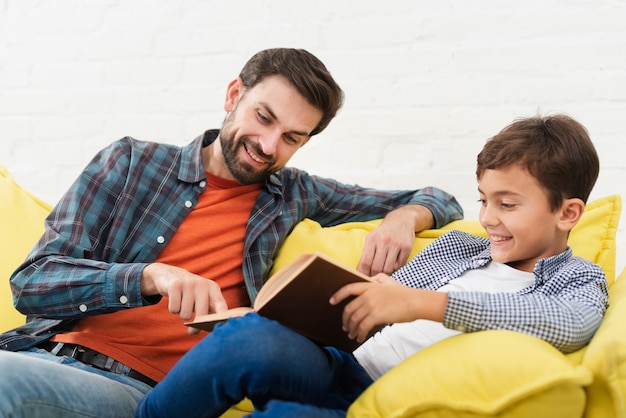 Foto gratuita feliz padre e hijo leyendo