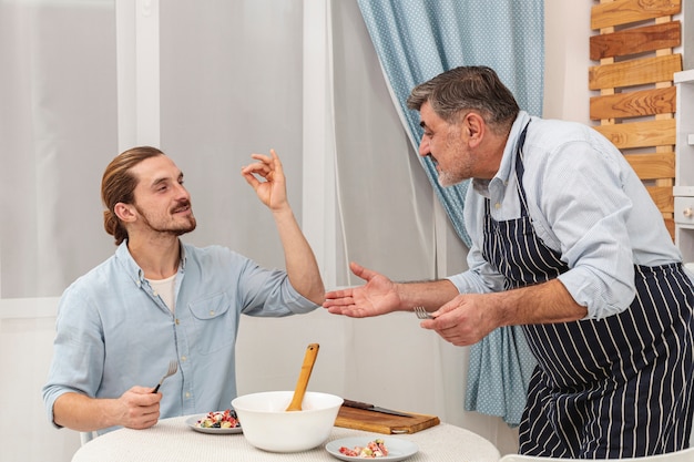 Feliz padre e hijo sirviendo la cena