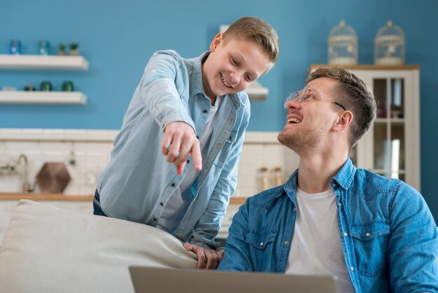 Feliz padre e hijo usando la computadora portátil