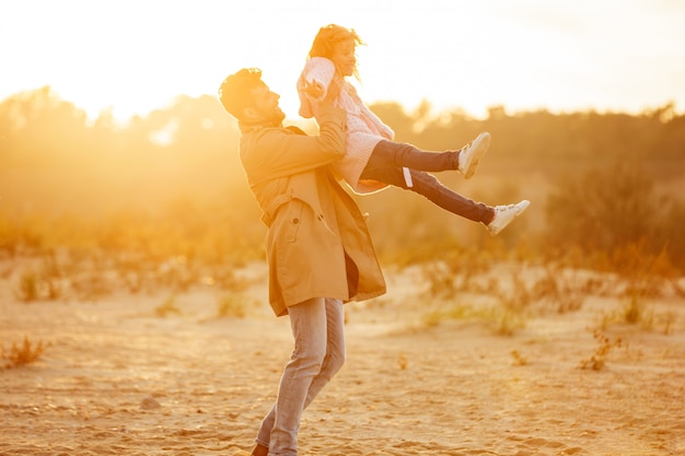 Feliz padre jugando con su pequeña hija en la playa