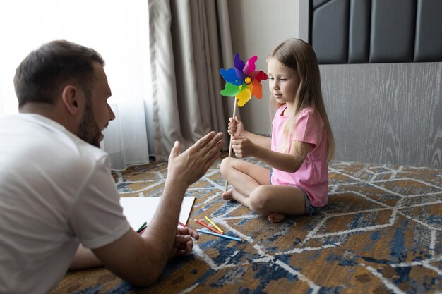 Foto gratuita feliz padre sonriente y su hija en casa