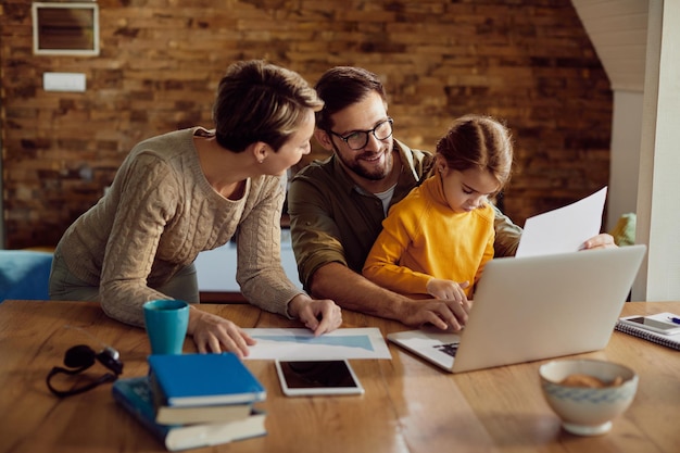 Foto gratuita feliz padre trabajador usando laptop con su familia en casa