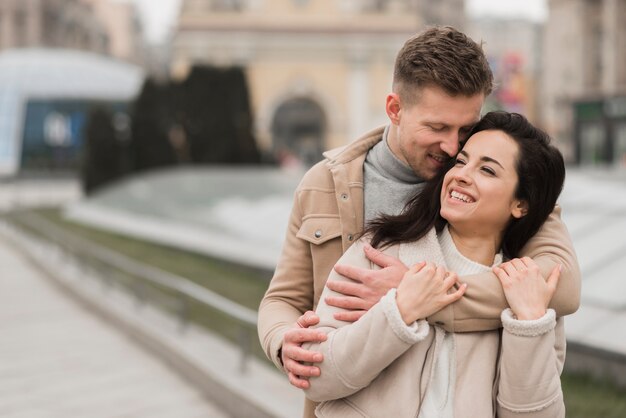 Feliz pareja abrazada al aire libre