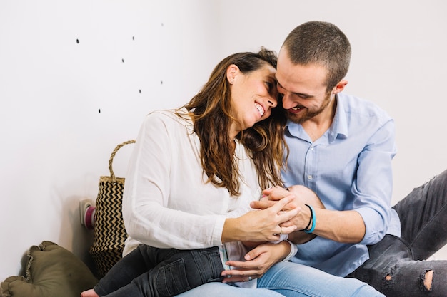 Feliz pareja abrazando bebé