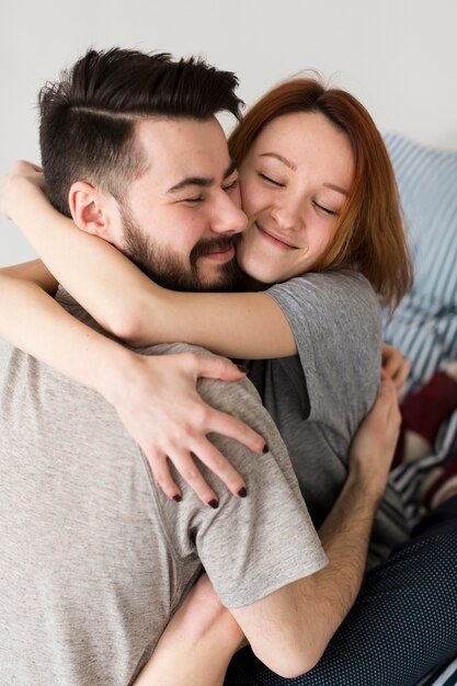 Feliz pareja abrazándose en el interior