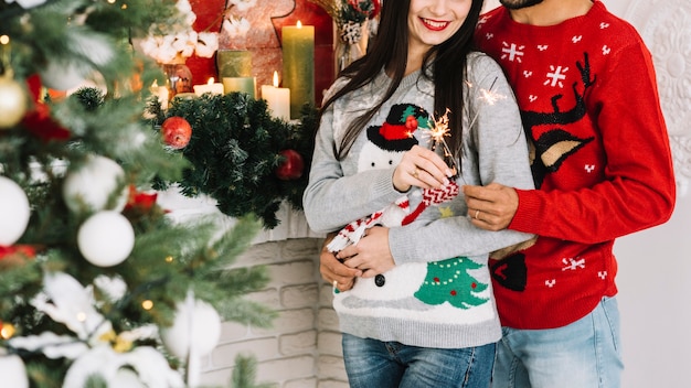 Foto gratuita feliz pareja abrazándose con luces de bengala