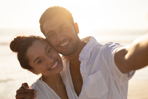 Feliz pareja abrazándose en la playa 4k