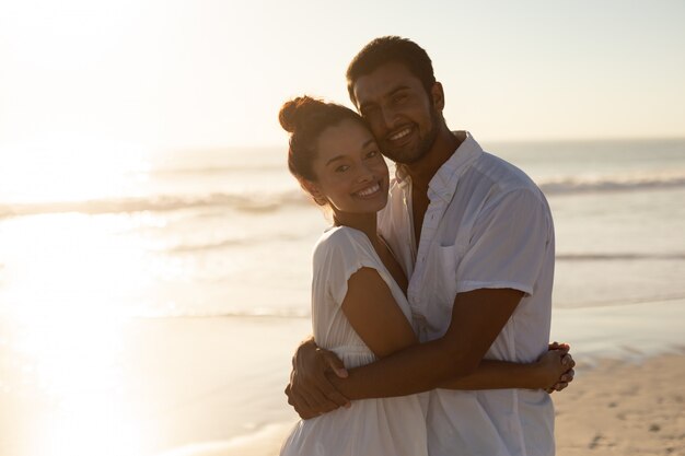 Feliz pareja abrazándose en la playa