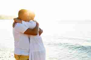 Foto gratuita feliz pareja abrazándose en la playa