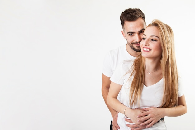 Feliz pareja abrazándose y sonriendo