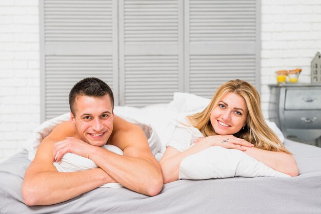 Feliz pareja acostada en la cama