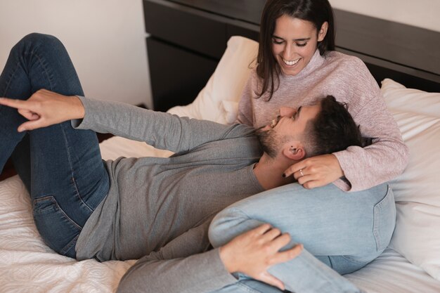 Feliz pareja acostada en la cama