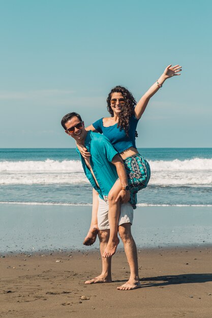 Feliz pareja amorosa divirtiéndose en la playa de arena de verano