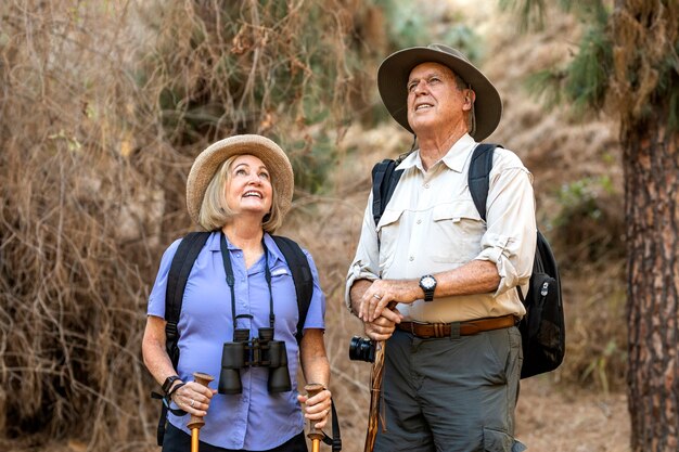 Feliz pareja de ancianos disfrutando de la naturaleza en el bosque californiano