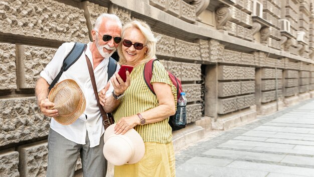 Feliz pareja de ancianos mirando el teléfono