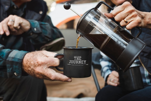 Feliz pareja de ancianos tomando un café en la carpa en el bosque