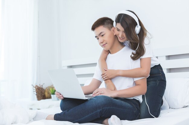 Feliz pareja asiática en la cama en su casa