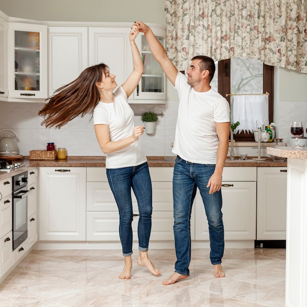 Feliz pareja bailando en la cocina