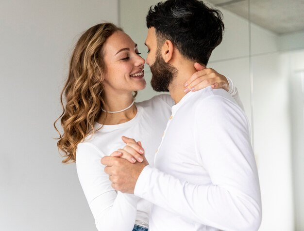 Feliz pareja bailando juntos en casa