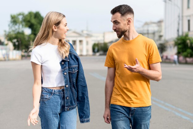 Feliz pareja caminando y hablando en las calles