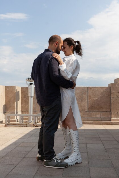 Feliz pareja casada abrazándose en la terraza de la torre celebrando la relación