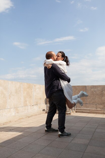 Feliz pareja casada celebrando el aniversario de la relación en la azotea del edificio