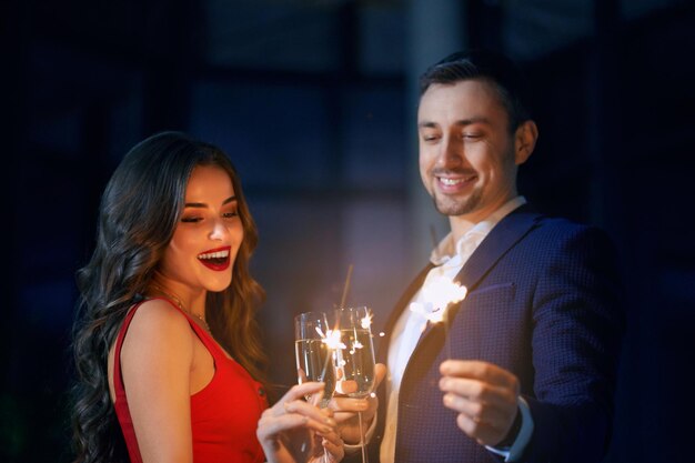Feliz pareja celebrando la fiesta con luces de Bengala