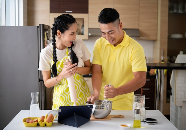 Feliz pareja cocinando en la cocina