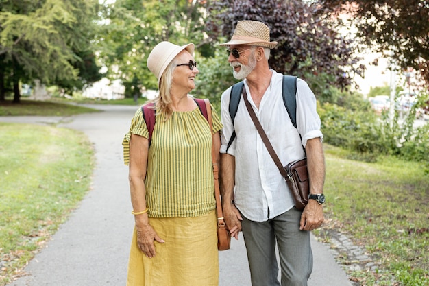 Feliz pareja cogidos de la mano y mirándose en el parque