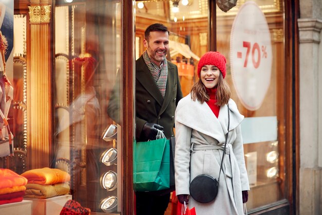 Feliz pareja de compras en rebajas de invierno