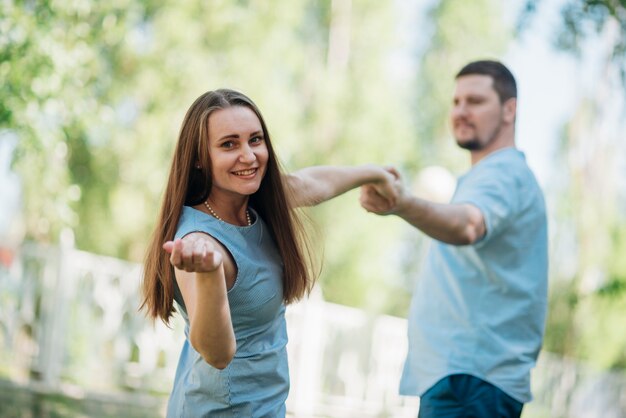 Feliz pareja coqueteando y tomados de la mano en el parque