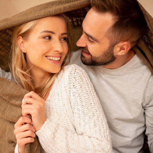 Feliz pareja cubierta con manta