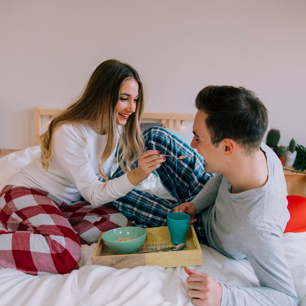 Feliz pareja desayunando en la cama