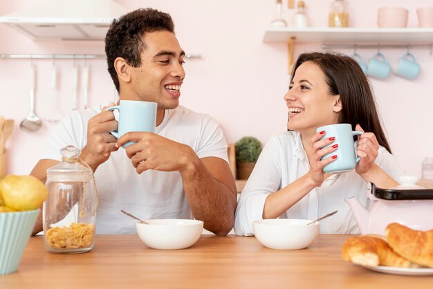 Feliz pareja desayunando en la cocina
