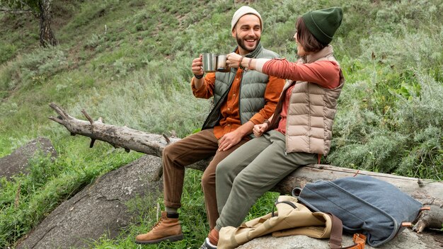 Feliz pareja disfrutando de una bebida caliente sentado en registro