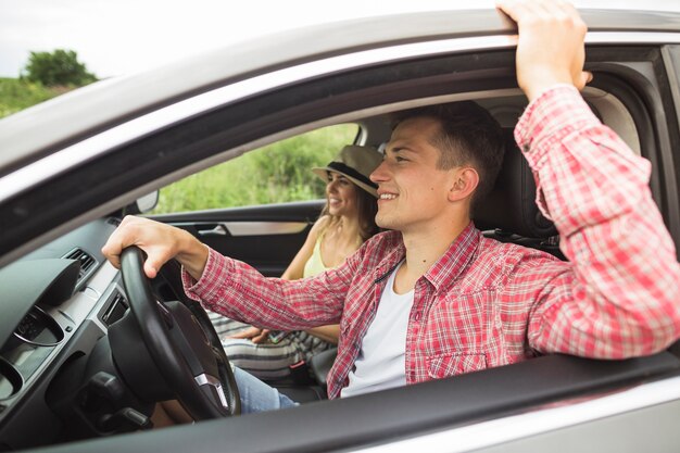 Feliz pareja disfrutando de viajar en el coche