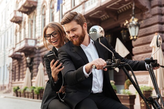 Feliz pareja elegante sentado en moto moderna al aire libre