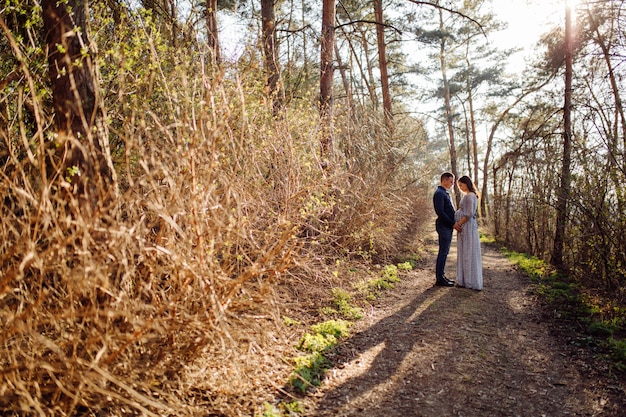 Foto gratuita feliz pareja embarazada en la naturaleza