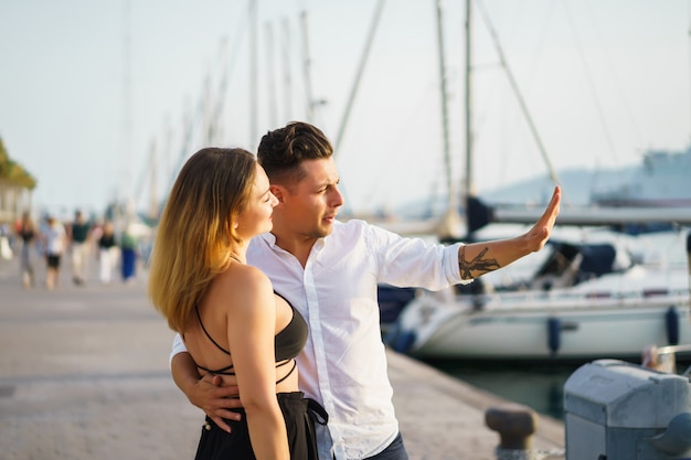 feliz pareja de enamorados camina en el puerto