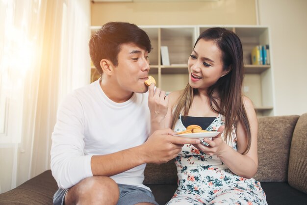 Feliz pareja es relajarse y jugar juntos la sala de estar.