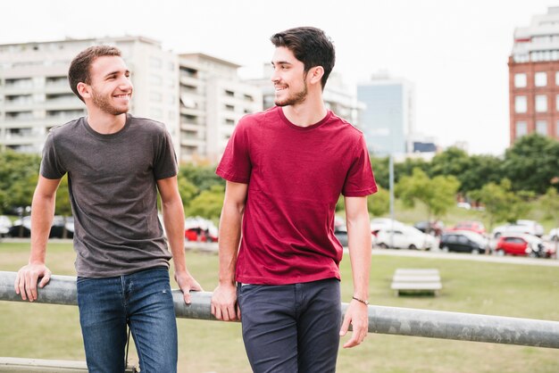 Feliz pareja gay de pie junto a la barandilla