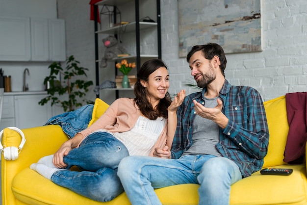 Foto gratuita feliz pareja hablando en el sofá