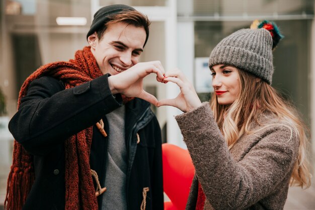 Feliz pareja haciendo gesto de corazón