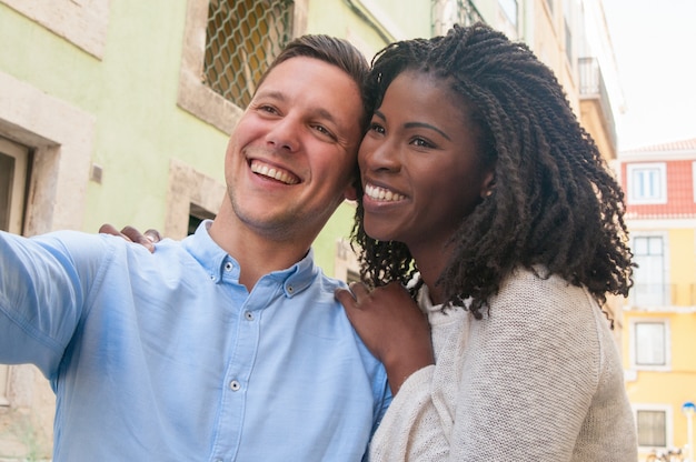 Feliz pareja intercultural soñadora disfrutando de una cita romántica en la ciudad