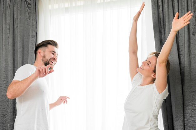 Feliz pareja en el interior haciendo cosas divertidas