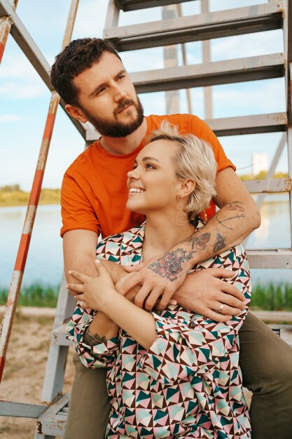 Feliz pareja joven abrazándose y riendo al aire libre en las escaleras