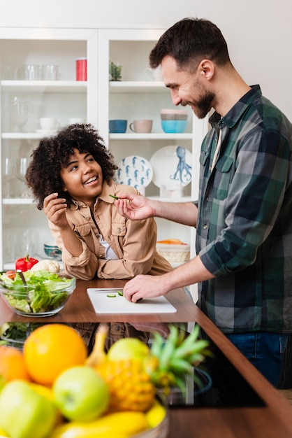 Foto gratuita feliz pareja joven cocinando juntos