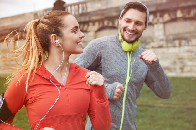 Feliz pareja joven corriendo al aire libre