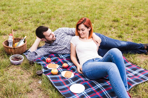 Feliz pareja joven disfrutando en el picnic