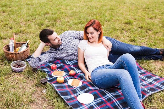 Feliz pareja joven disfrutando en el picnic